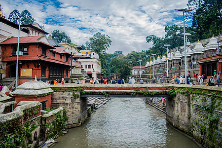 people walking on bridge under cloudy sky thumbnail