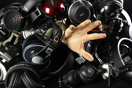 human hand surrounded by black and gray corded headphones thumbnail