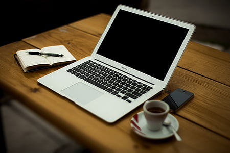 notebook, laptop and coffee on wooden desk thumbnail
