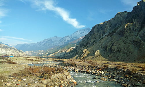 river near mountain under cloudy sky thumbnail