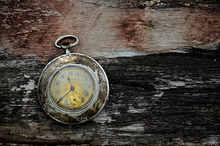 round pocket watch on brown and black surface thumbnail
