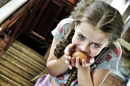 selective focus photography of girl holding egg thumbnail
