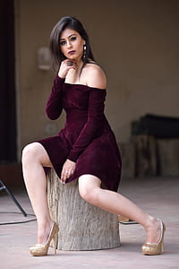 woman in maroon dress sitting on wood thumbnail