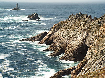 rocky mountain near lighthouse at daytime thumbnail