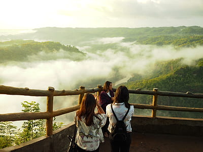 three women standing near mountain thumbnail