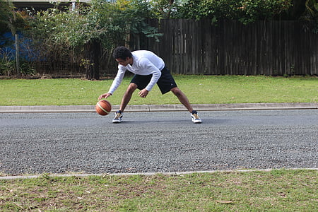 man in white long-sleeved shirt and black shorts playing basketball during daytime thumbnail