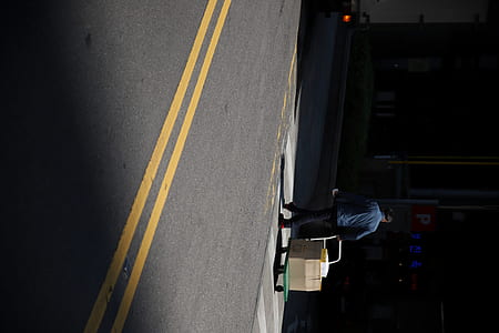 person pulling mover dolly beside road thumbnail