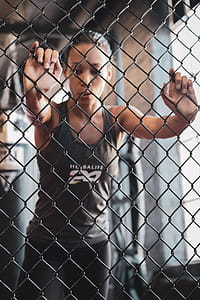 Selective Focus Photography Of Woman Touching Fence thumbnail