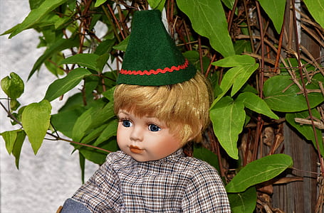 boy doll near green leaf plant thumbnail