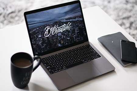 turned-on MacBook Pro beside black ceramic mug and black iPhone 8 Plus thumbnail