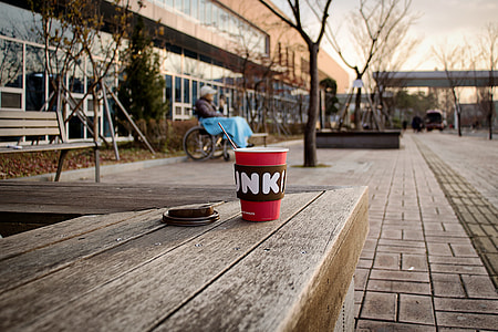 red disposable drinking cup on top of wooden surface thumbnail