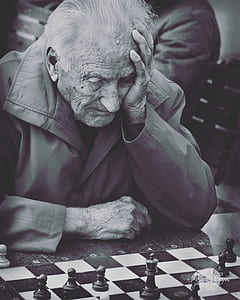 Grayscale Photo of Man Playing Chess thumbnail
