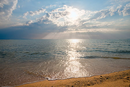 body of water under white clouds at daytime thumbnail