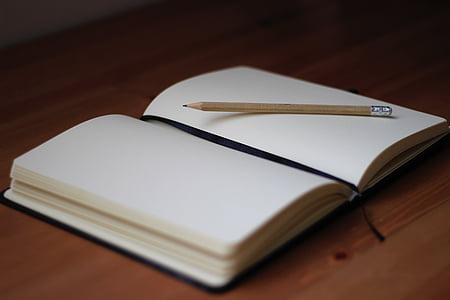 book and pencil on wooden surface thumbnail