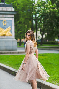 woman walking along the sidewalk during daytime thumbnail