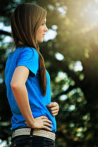 woman in blue shirt and denim bottoms with belt thumbnail