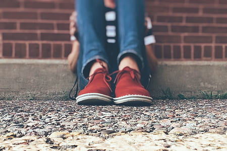 person wearing pair of red low-top sneakers thumbnail