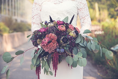 shallow focus photography of person holding flowers thumbnail