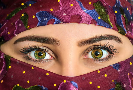 close-up photography of woman wearing pink, blue, yellow, and green polka-dot camouflage hijab headscarf thumbnail