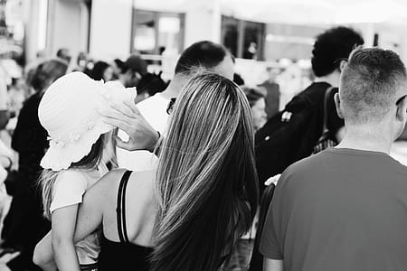 Woman Carrying a child Wearing a Sun Hat standing next to a man thumbnail