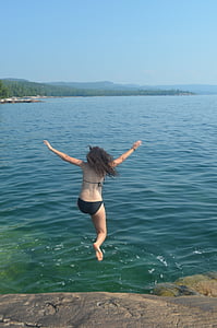 woman jumping on body of water thumbnail