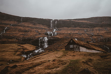 landscape photography of cabin near waterfalls thumbnail