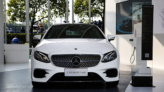 white Mercedes-Benz vehicle parked beside white painted wall thumbnail