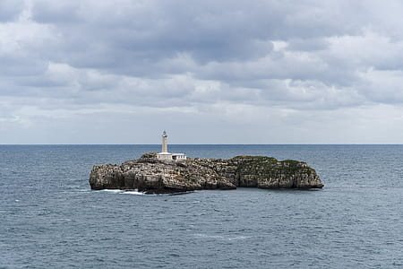 white lighthouse on island thumbnail