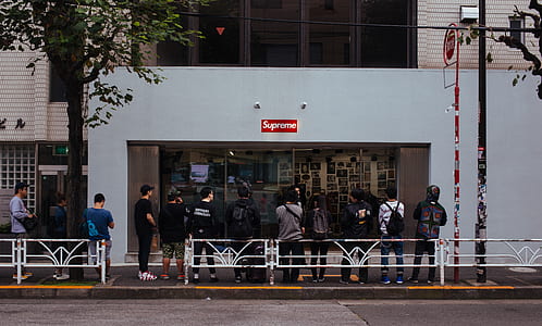 group of people falling in line in front of Supreme store taken at daytime thumbnail