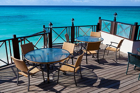 two round glass-top table with chair set at seashore thumbnail