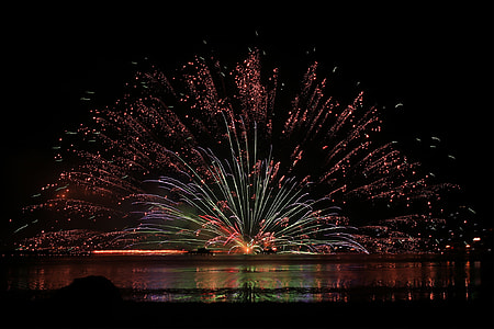 fireworks near body of water during nighttime thumbnail