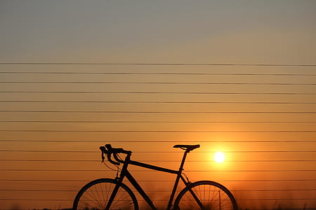 silhouette photo of road bike at golden hour thumbnail