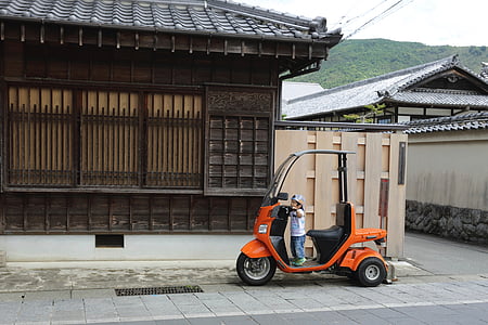 boy riding scooter near house thumbnail