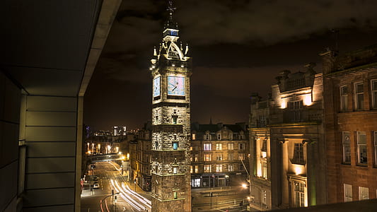 brown concrete tower with clock with lights turned-on at night thumbnail