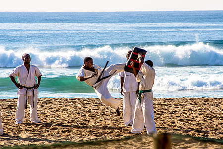 martial artists trains by the seashore during daytime thumbnail