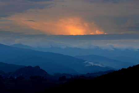 silhouette of mountain under cloudy sky at sunset thumbnail