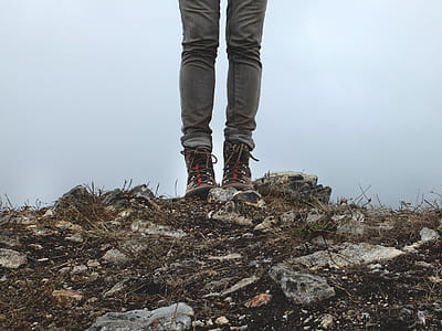 person wearing black-and-red high-top sneakers on stone thumbnail