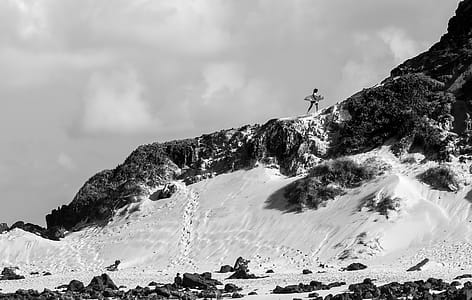 Person Holding Surfboard on Cliff thumbnail