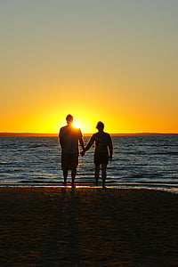 couple holding hands near beach during golden hour thumbnail