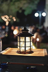 focus photography of brown lantern on table at night time thumbnail