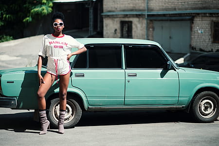 Woman Standing in Front of Teal Sedan thumbnail