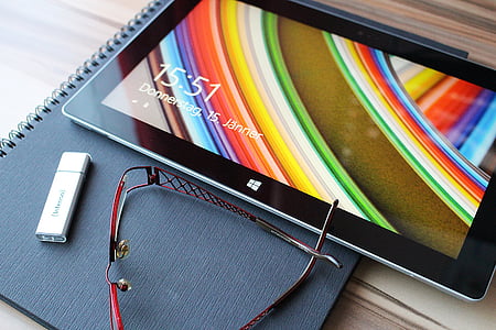 black windows tablet, eyeglasses and flashdrive thumbnail