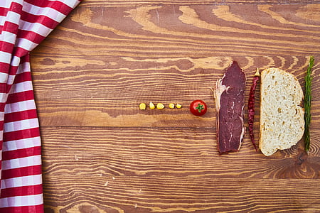 asparagus, sliced bread, chili, raw meat, tomato on brown wooden surface thumbnail