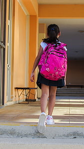 girl wearing backpack while walking on pathway thumbnail