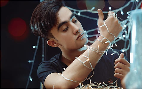 Man Holding White String Lights thumbnail