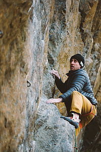 man climbing rock during daytime thumbnail