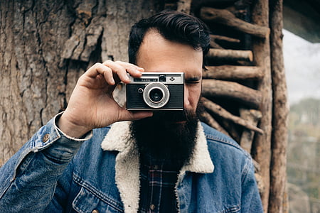 man in blue denim jacket holding camera thumbnail