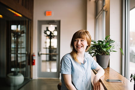 woman sitting beside the window smiling thumbnail