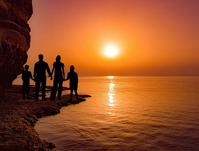 silhouette photography of family standing on shore thumbnail