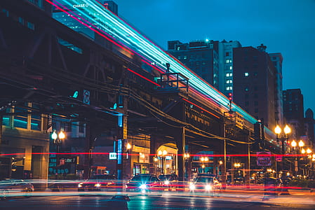 cars under railroad near buildings thumbnail